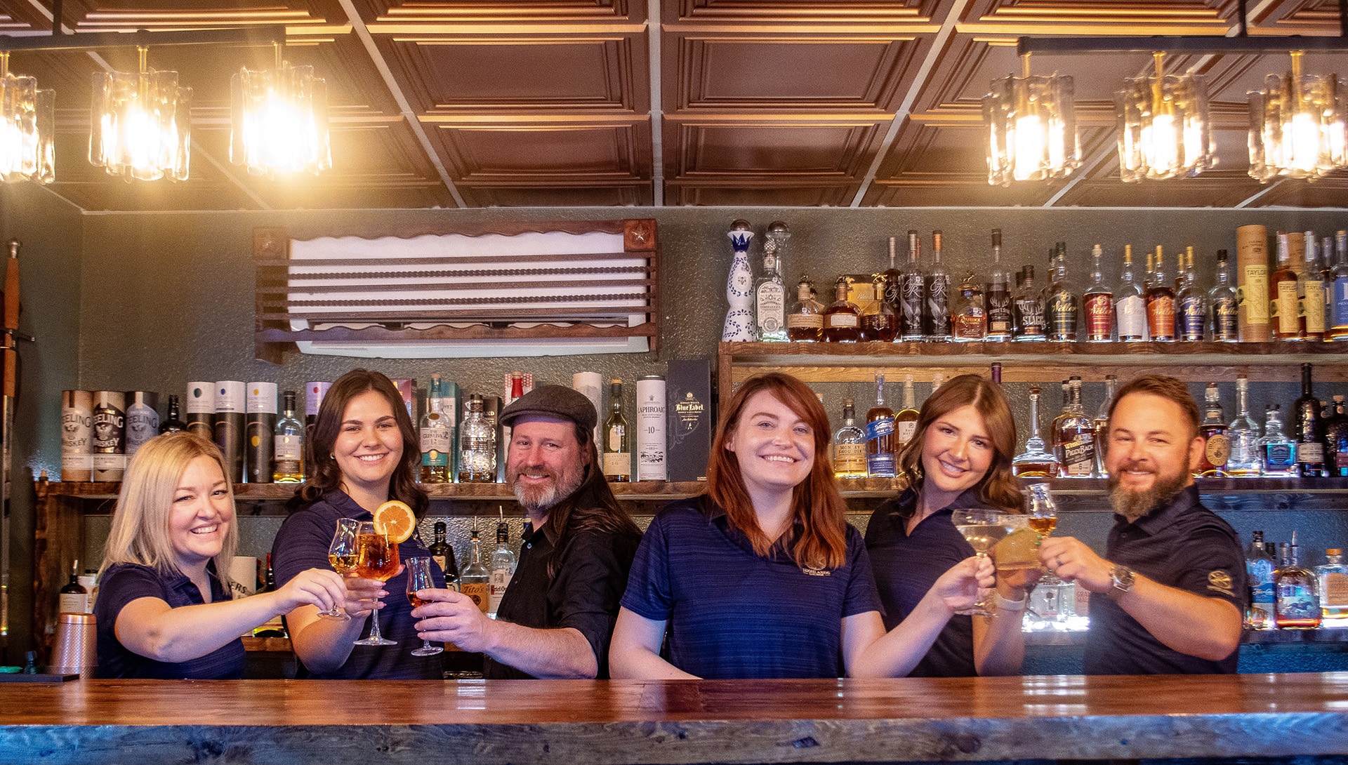 The Highlands Lounge team gathered at the bar in Belton, Texas, ready to welcome guests with whiskey hospitality